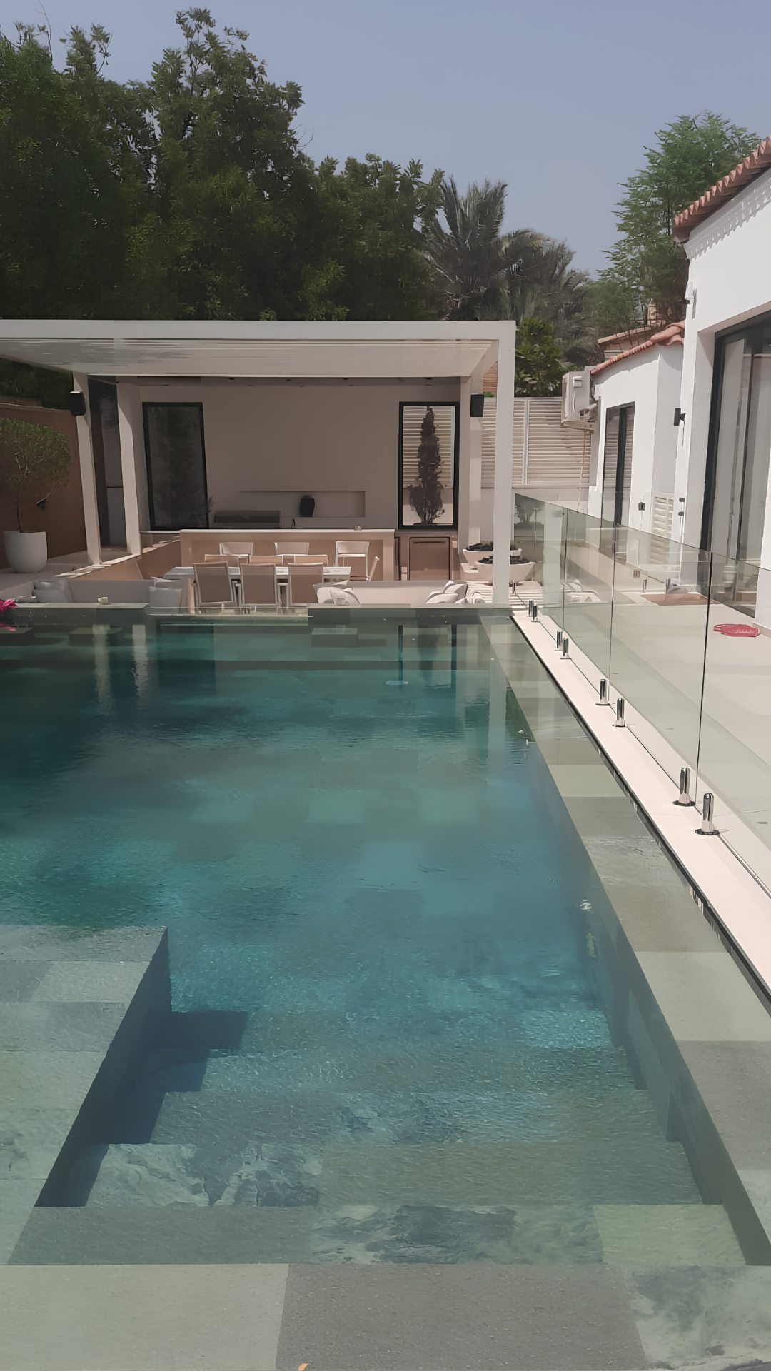 Bespoke frameless glass fence running beside a luxury villa pool