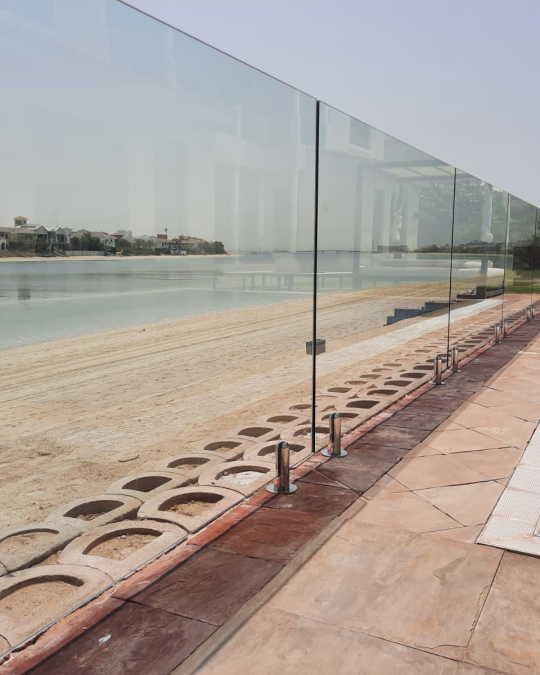 Frameless commercial glass fence along a waterfront promenade at Palm Jumeirah