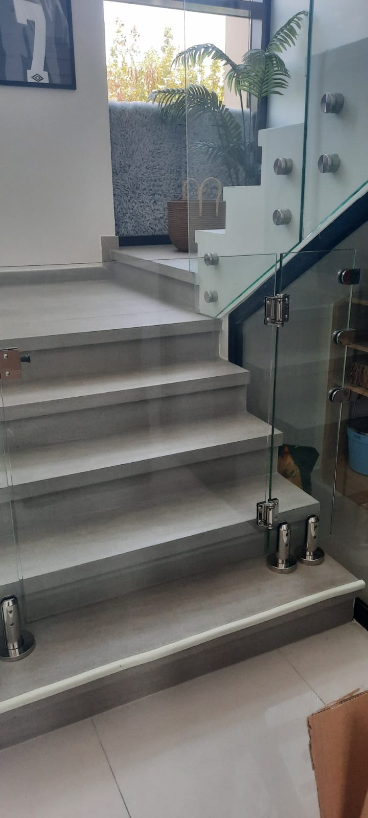 Self closing glass stair gate with stainless steel hinges on indoor steps